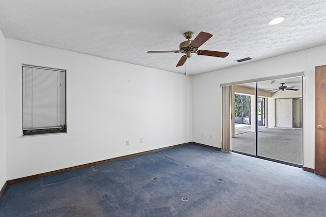 carpeted empty room with ceiling fan and a textured ceiling