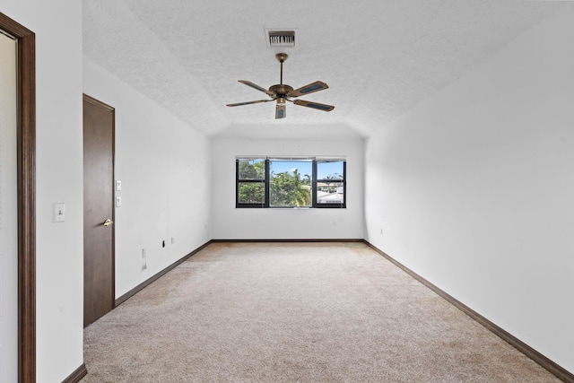 carpeted spare room with ceiling fan and a textured ceiling