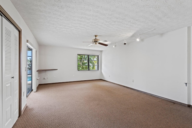 carpeted spare room with a textured ceiling and ceiling fan