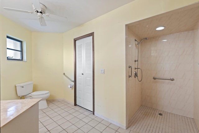 bathroom with ceiling fan, a tile shower, toilet, vanity, and tile patterned flooring