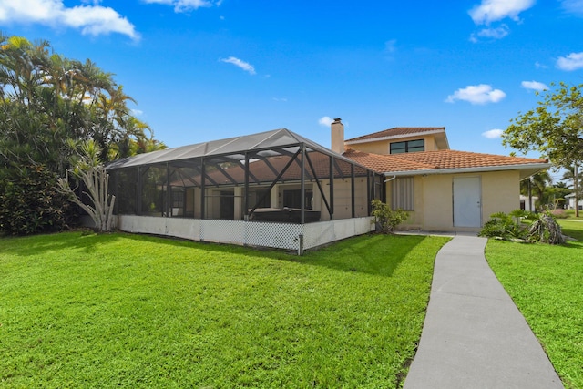 view of front of property with a front lawn and glass enclosure