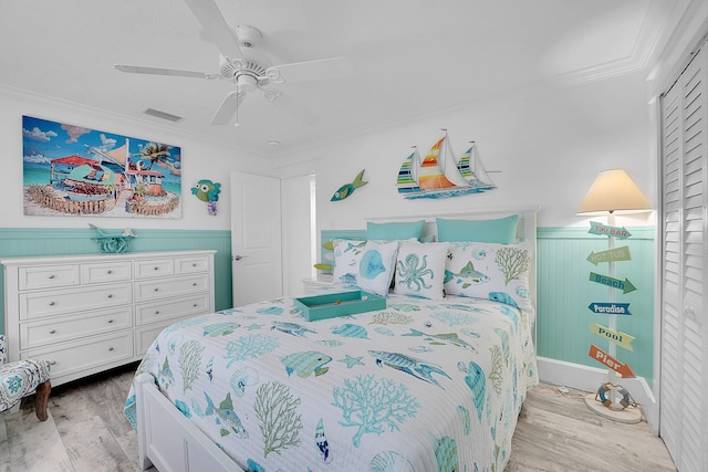 bedroom with ceiling fan, light hardwood / wood-style floors, crown molding, and a closet