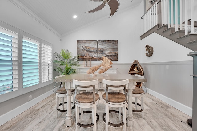 dining area featuring light wood-type flooring, crown molding, ceiling fan, and lofted ceiling