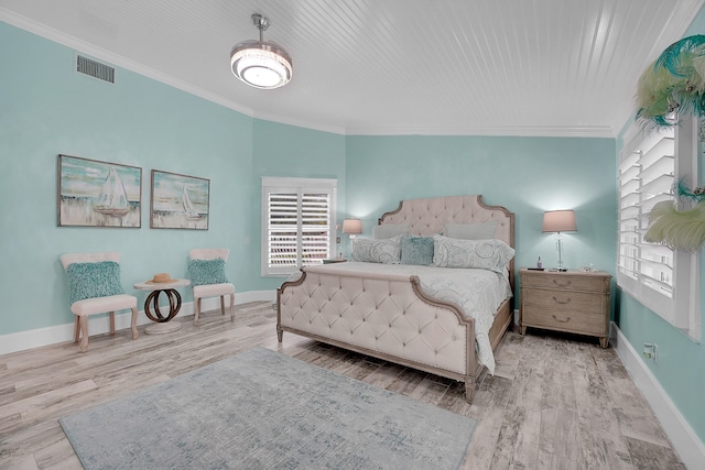 bedroom with light wood-type flooring and crown molding