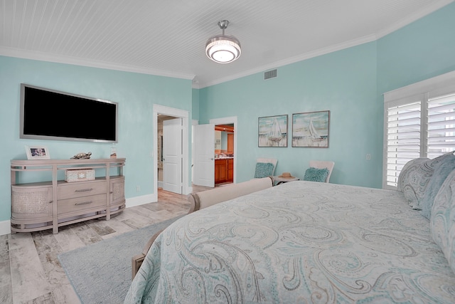 bedroom featuring crown molding, light hardwood / wood-style flooring, and ensuite bathroom