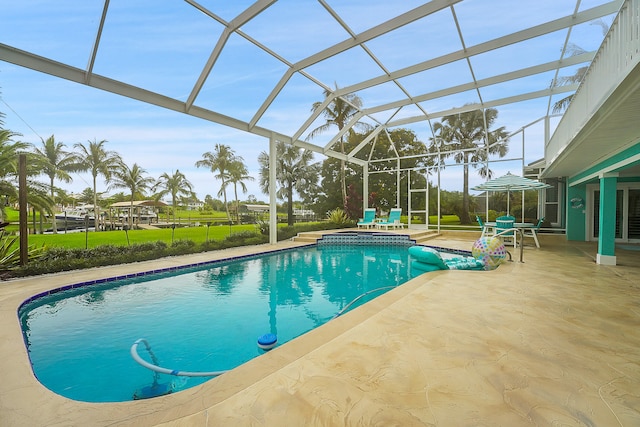 view of pool featuring glass enclosure and a patio