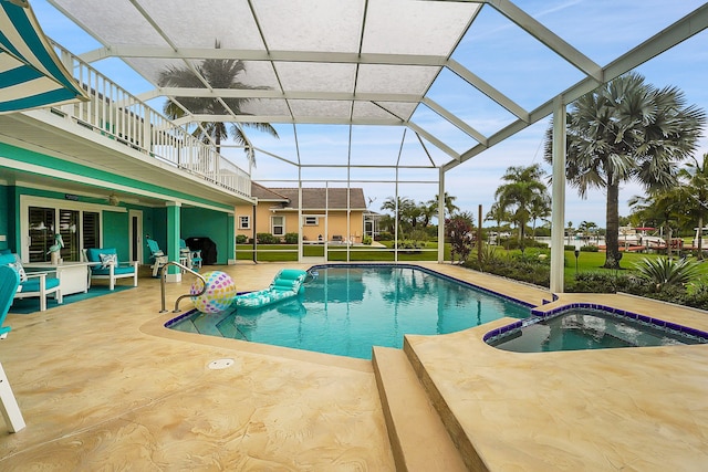 view of pool with a patio area and glass enclosure