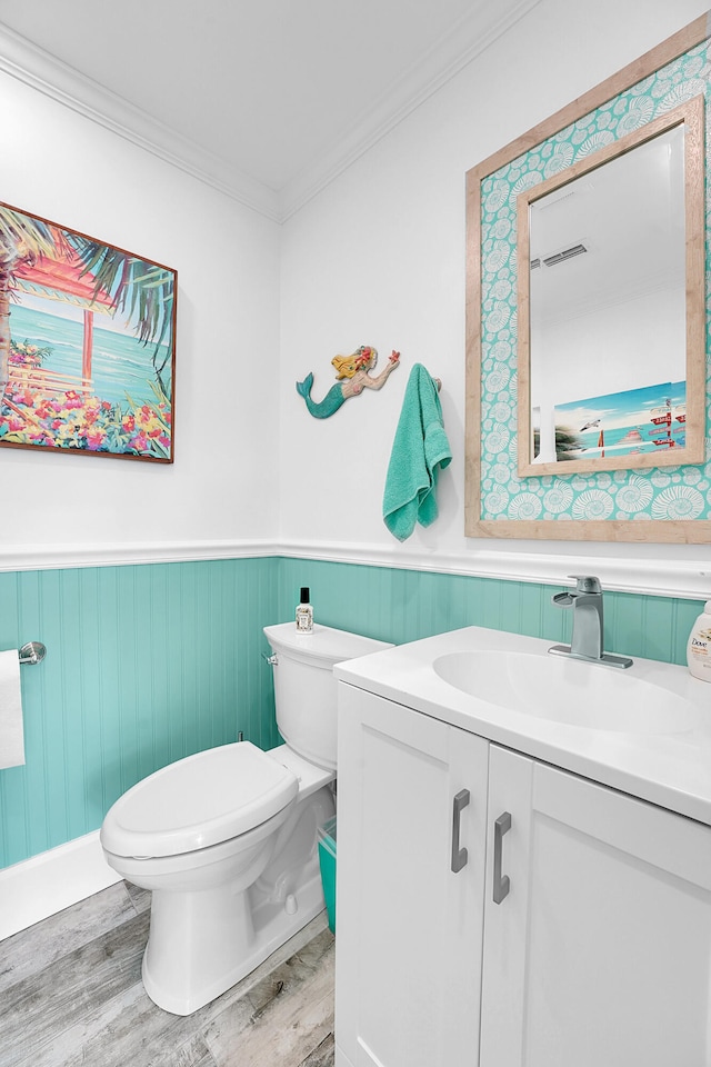 bathroom featuring toilet, hardwood / wood-style floors, vanity, and ornamental molding