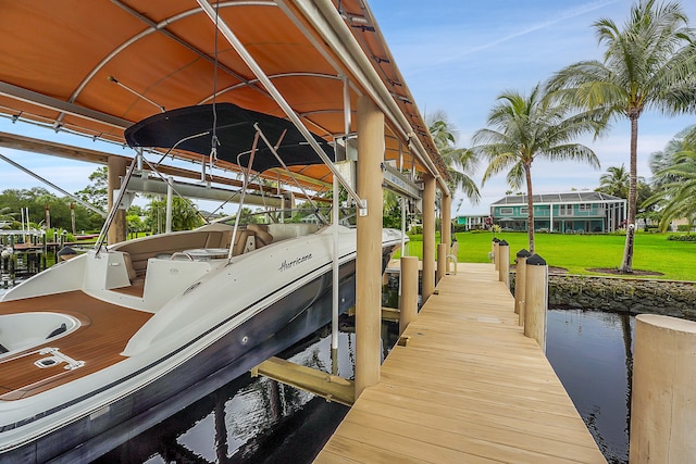 view of dock with a yard and a water view