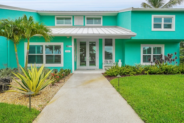 view of front of house with french doors and a front lawn