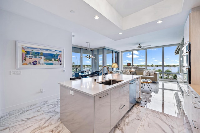 kitchen featuring decorative light fixtures, expansive windows, sink, a center island with sink, and light tile patterned floors