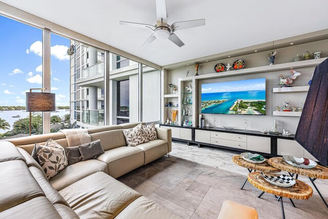 living room with a healthy amount of sunlight, ceiling fan, and floor to ceiling windows