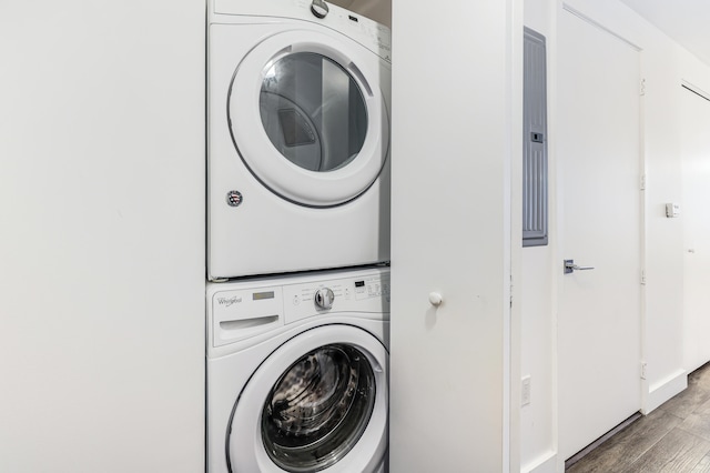 clothes washing area featuring hardwood / wood-style floors and stacked washing maching and dryer