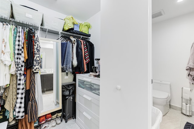 walk in closet with light tile patterned flooring