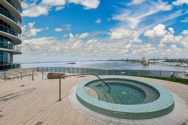 view of swimming pool featuring a water view and a community hot tub