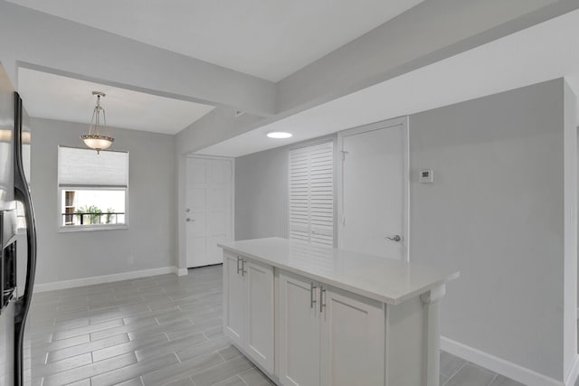 kitchen with white cabinetry, hanging light fixtures, and fridge with ice dispenser