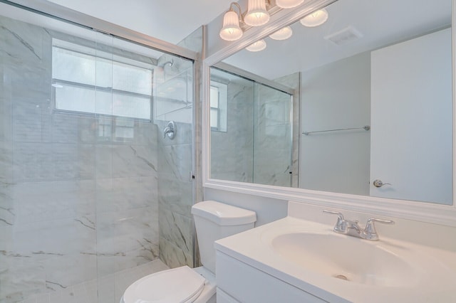 bathroom featuring toilet, vanity, and an enclosed shower