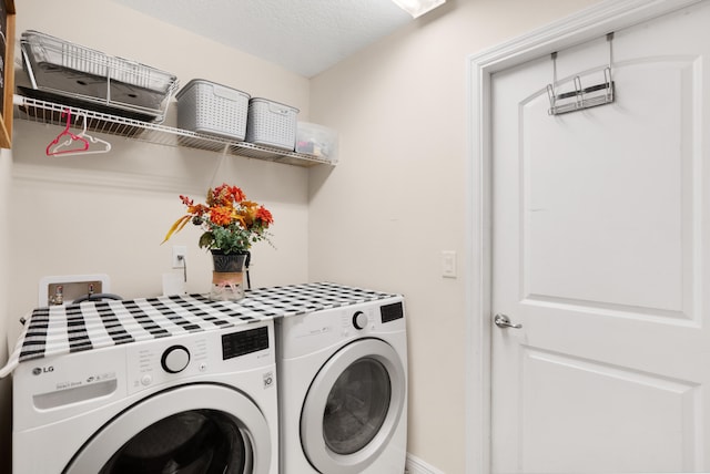 laundry room featuring independent washer and dryer and a textured ceiling