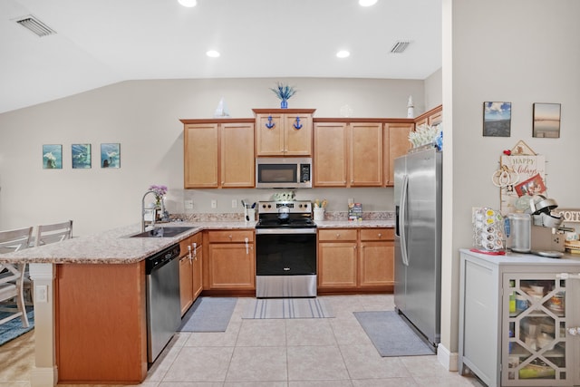 kitchen featuring lofted ceiling, kitchen peninsula, sink, light tile patterned floors, and appliances with stainless steel finishes