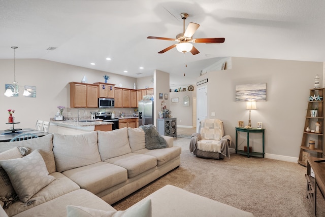 living room featuring light carpet, lofted ceiling, sink, and ceiling fan with notable chandelier