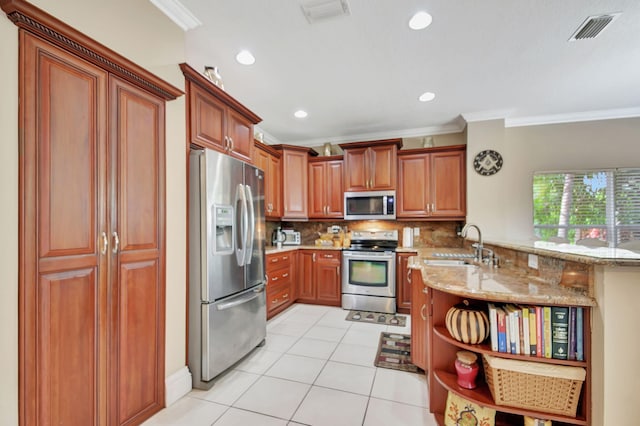 kitchen with stainless steel appliances, sink, light stone countertops, kitchen peninsula, and backsplash