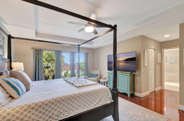 bedroom with ceiling fan, dark wood-style floors, baseboards, and a raised ceiling