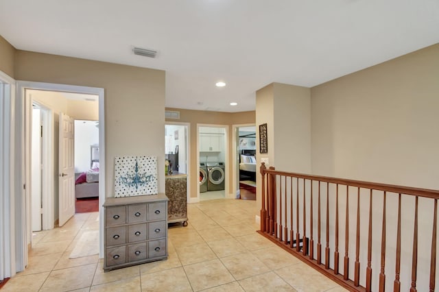 hallway with visible vents, washer and clothes dryer, recessed lighting, and light tile patterned floors