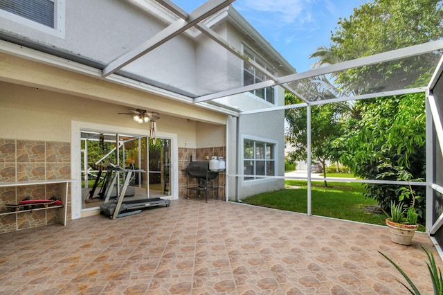 unfurnished sunroom with ceiling fan