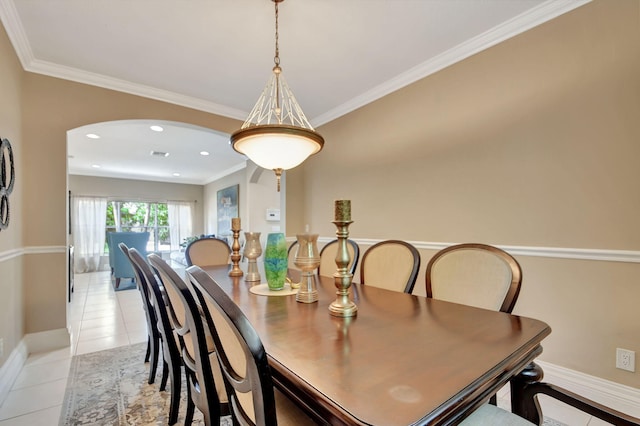 dining space with arched walkways, light tile patterned floors, baseboards, and ornamental molding