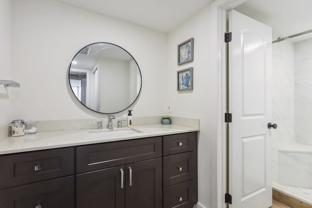 bathroom featuring a shower and vanity