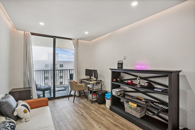 living room with expansive windows and light hardwood / wood-style flooring