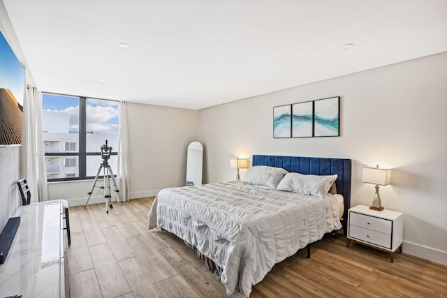 bedroom with baseboards and wood finished floors