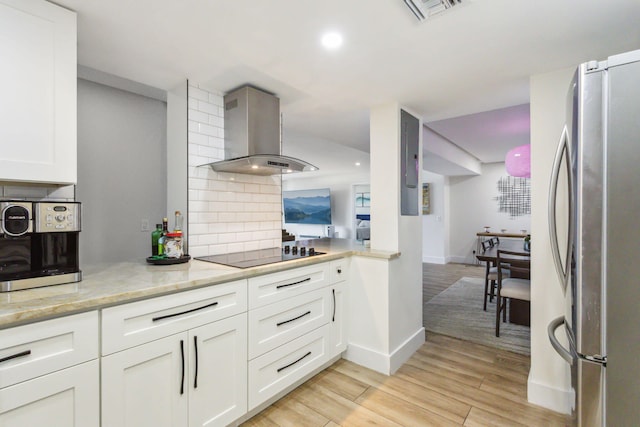 kitchen with stainless steel fridge, backsplash, light hardwood / wood-style floors, black electric cooktop, and wall chimney exhaust hood