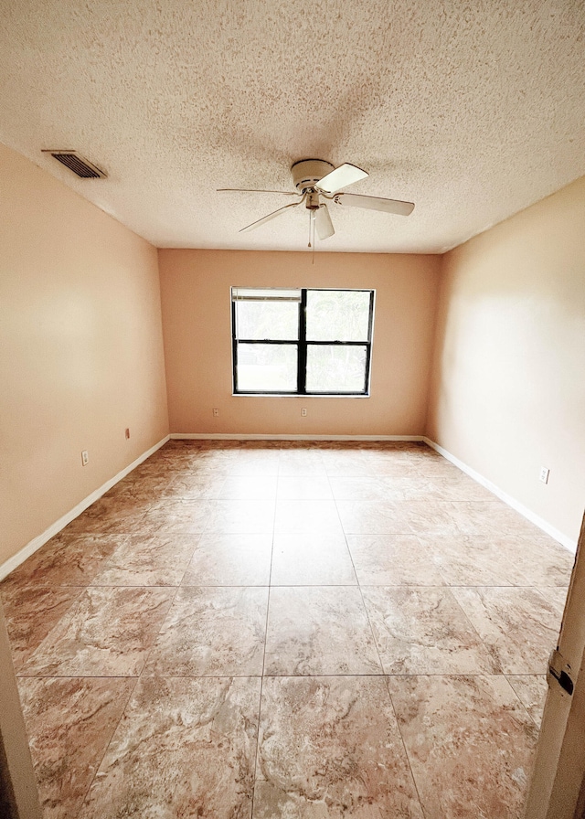 spare room featuring a textured ceiling, tile patterned floors, and ceiling fan