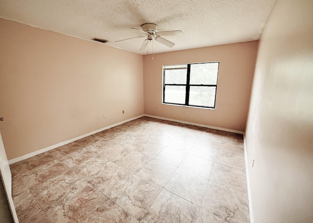 empty room with ceiling fan, a textured ceiling, and light tile patterned floors