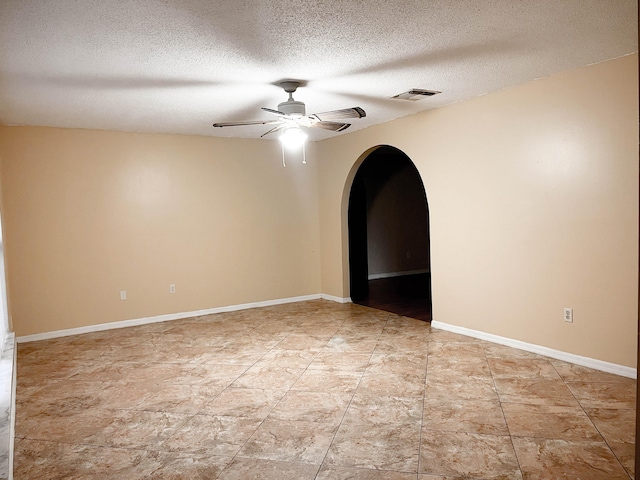 tiled spare room featuring a textured ceiling and ceiling fan