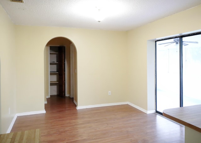 spare room featuring a textured ceiling and hardwood / wood-style floors