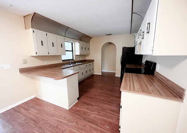 kitchen with dark hardwood / wood-style flooring, a textured ceiling, range, white cabinetry, and sink