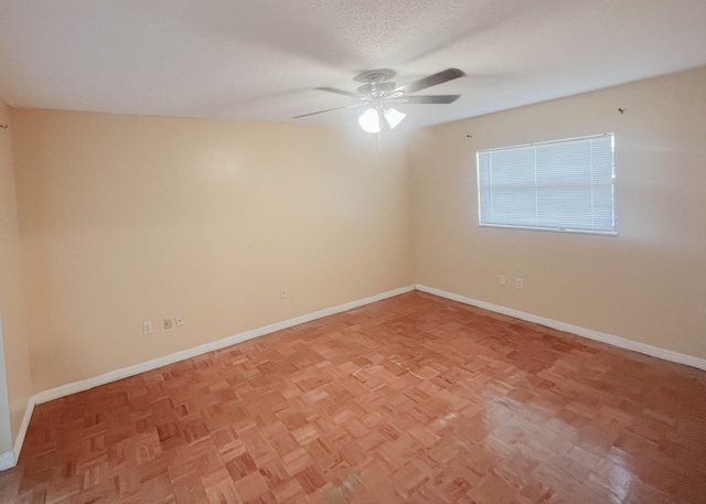 unfurnished room with ceiling fan, a textured ceiling, and light parquet floors