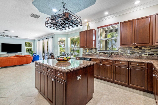 kitchen with backsplash, a textured ceiling, ornamental molding, and a center island