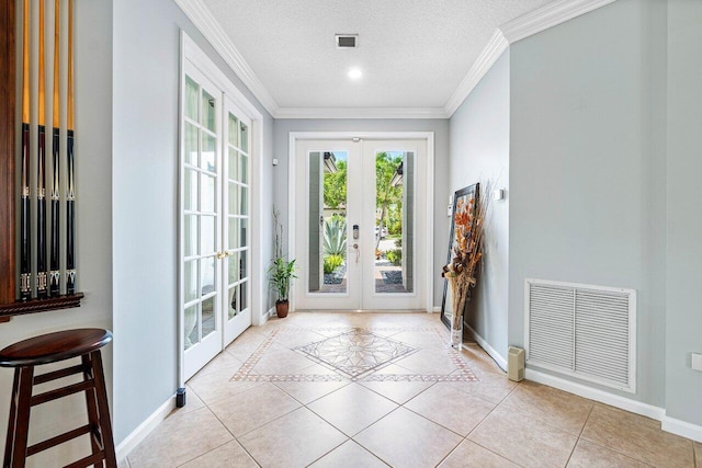 doorway with a textured ceiling, light tile patterned floors, french doors, and crown molding