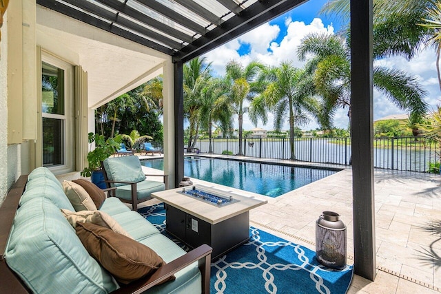 view of pool with an outdoor living space with a fire pit, a patio, and a water view