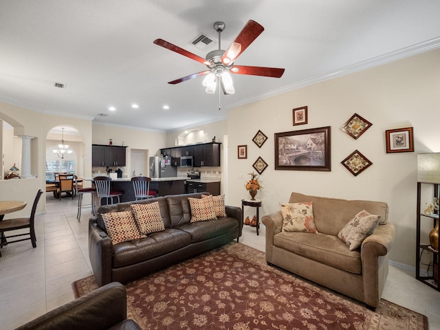 tiled living room with ornate columns, ornamental molding, and ceiling fan with notable chandelier