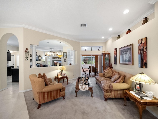 living room featuring decorative columns, crown molding, and light tile patterned flooring