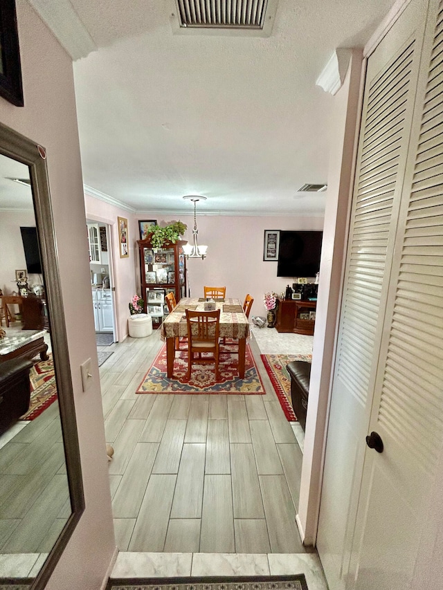 interior space with a notable chandelier and crown molding