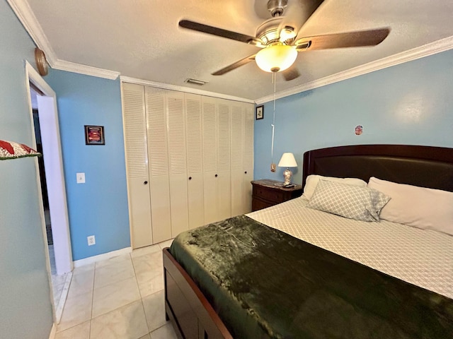 bedroom featuring light tile patterned flooring, a closet, ceiling fan, and crown molding