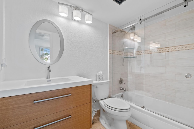 full bathroom featuring toilet, a textured wall, enclosed tub / shower combo, and vanity