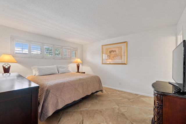 bedroom with baseboards and a textured ceiling