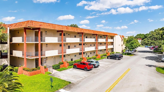 view of building exterior with uncovered parking and a residential view