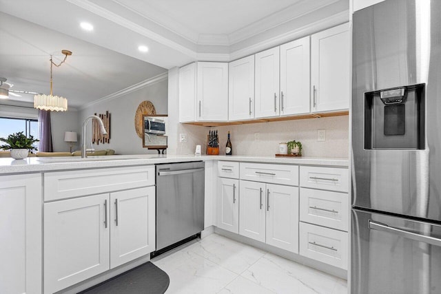 kitchen featuring crown molding, a notable chandelier, backsplash, white cabinets, and appliances with stainless steel finishes